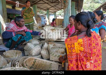 Koraput, Inde - février 2021 : des femmes d'Adivasi de la tribu Kondh achètent des corbeilles de canne sur le marché de Koraput le 21 février 2021 à Odisha, Inde. Banque D'Images