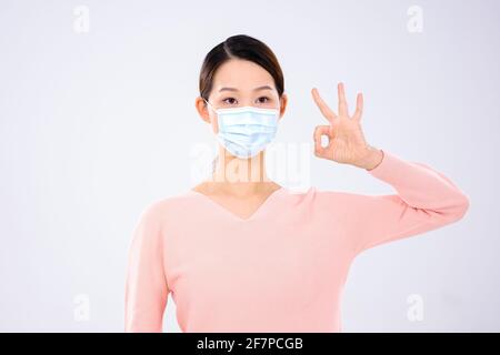 Une jeune femme portant un masque en a fait un signe vue avant du consentement Banque D'Images