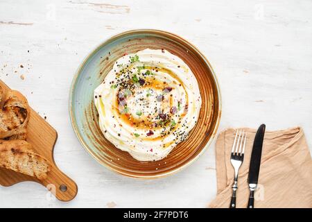 Feta aux herbes, miel épicé et mini baguette sur une assiette sur fond rustique. Menu végétarien, nourriture saine. Prévention de la carence en vitamines. Banque D'Images