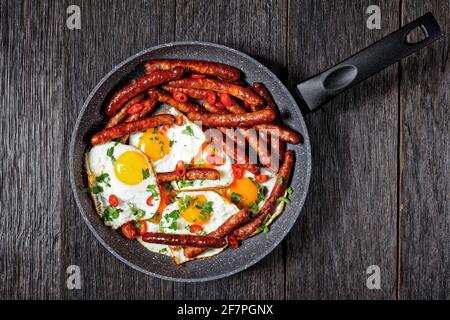 Longaniza con huevos, petit déjeuner de saucisses avec des œufs frits dans une poêle sur une table en bois, vue horizontale d'en haut, cuisine mexicaine, plat, sp. Gratuit Banque D'Images