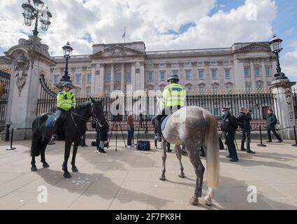 Les policiers de la police métropolitaine observent à cheval tandis que les médias se réunissent à l'extérieur de Buckingham Palace, Londres, où le drapeau de l'Union vole à mi-mât après l'annonce de la mort du duc d'Édimbourg à l'âge de 99 ans. Date de la photo: Vendredi 9 avril 2021. Banque D'Images