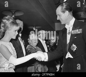 Photo du dossier en date du 25/02/64 du duc d'Édimbourg, assisté à la Royal film Performance à Londres, se serre la main avec l'actrice suédoise Britt Ekland. Le duc d’Édimbourg était lié à de nombreuses femmes glamour, mais les proches de Philip ont toujours insisté sur le fait que les revendications d’affaires étaient fausses. Date de publication : vendredi 9 avril 2021. Banque D'Images