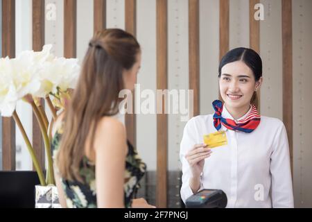 Le client effectue le paiement par carte pour les services au comptoir d'enregistrement de l'hôtel, les clients s'étant rendus dans un centre de villégiature Banque D'Images