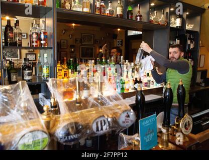 Londres, Royaume-Uni, 9 avril 2021 : le pub Abbeville, à Clapham, se prépare à rouvrir pour prendre un verre en plein air et dîner sur sa terrasse à partir du 12 avril. Tandis que les robinets à bière sont maintenus propres sous un emballage en plastique, le barman Klodian dépoussiérte des bouteilles de spiritueux. Anna Watson/Alay Live News Banque D'Images