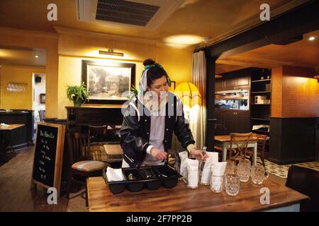 Londres, Royaume-Uni, 9 avril 2021 : au pub Abbeville, à Clapham, le directeur Armanda polit les couverts en vue de leur réouverture à partir du 12 avril. Le Manager Armanda polit les couverts. Les clients seront servis des boissons et des repas sur la terrasse extérieure et des tables sur le trottoir. Anna Watson/Alay Live News Banque D'Images