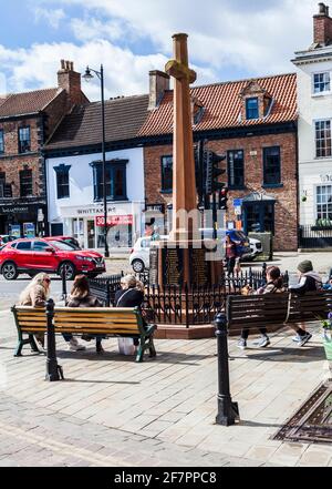 Les gens se sont assis autour du mémorial de guerre à High Street, Yarm, Angleterre, Royaume-Uni Banque D'Images