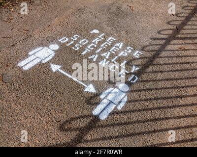 Veuillez garder le signe socialement distancé sur un trottoir dans le Matlock Bath Derbyshire Angleterre en avril 2021. Banque D'Images