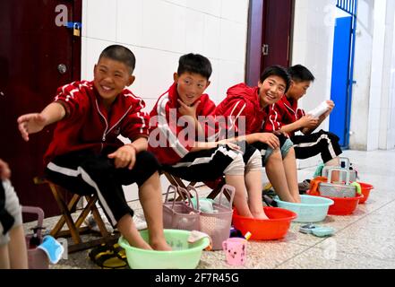 (210409) -- DENGFENG, 9 avril 2021 (Xinhua) -- les joueurs de l'équipe de hockey sur glace Shaolin Tagou se lavent dans leur dortoir de l'école d'arts martiaux Shaolin Tagou, Dengfeng City, province de Henan, centre de la Chine, le 31 mars 2021. Shaolin Tagou Martial Arts School, à quelques kilomètres du temple de Shaolin, lieu de naissance de Shaolin Kung Fu, construit son équipe de hockey sur glace. Les élèves apprennent le sport sur des patins à roulettes dans une patinoire de taille standard recouverte de plancher, au lieu de glace. La pratique des arts martiaux renforce leur physique et leur procure des qualités athlétiques dont le hockey sur glace a besoin Banque D'Images