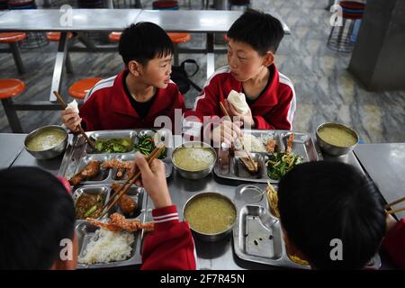 (210409) -- DENGFENG, 9 avril 2021 (Xinhua) -- Liu Ziqian (en haut R) et Fang Yuhao (en haut L) de l'équipe de hockey sur glace Shaolin Tagou dînez à l'école d'arts martiaux Shaolin Tagou, Dengfeng City, dans la province de Henan, au centre de la Chine, le 31 mars 2021. Shaolin Tagou Martial Arts School, à quelques kilomètres du temple de Shaolin, lieu de naissance de Shaolin Kung Fu, construit son équipe de hockey sur glace. Les élèves apprennent le sport sur des patins à roulettes dans une patinoire de taille standard recouverte de plancher, au lieu de glace. La pratique des arts martiaux renforce leurs physiques et leur fournit des qualités athlétiques que la glace hocke Banque D'Images