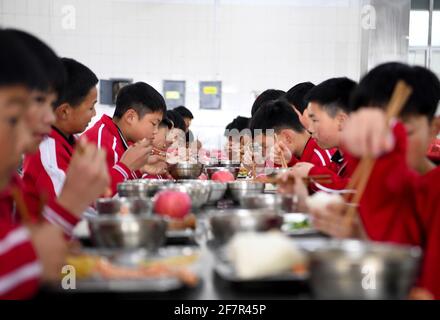 (210409) -- DENGFENG, 9 avril 2021 (Xinhua) -- les joueurs de l'équipe de hockey sur glace Shaolin Tagou déjeunent à l'école d'arts martiaux Shaolin Tagou, à Dengfeng City, dans la province de Henan, au centre de la Chine, le 31 mars 2021. Shaolin Tagou Martial Arts School, à quelques kilomètres du temple de Shaolin, lieu de naissance de Shaolin Kung Fu, construit son équipe de hockey sur glace. Les élèves apprennent le sport sur des patins à roulettes dans une patinoire de taille standard recouverte de plancher, au lieu de glace. La pratique des arts martiaux renforce leur physique et leur procure des qualités athlétiques dont le hockey sur glace a besoin, a déclaré le directeur de la formation Banque D'Images