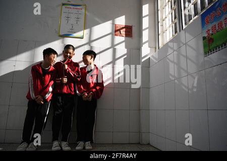 (210409) -- DENGFENG, le 9 avril 2021 (Xinhua) -- Liu Ziqian, Huang Yuuan et Fang Yuhao (de gauche à droite) de l'équipe de hockey sur glace Shaolin Tagou bavarde dans leur dortoir de l'école d'arts martiaux Shaolin Tagou, à Dengfeng City, dans la province de Henan, au centre de la Chine, le 31 mars 2021. Shaolin Tagou Martial Arts School, à quelques kilomètres du temple de Shaolin, lieu de naissance de Shaolin Kung Fu, construit son équipe de hockey sur glace. Les élèves apprennent le sport sur des patins à roulettes dans une patinoire de taille standard recouverte de plancher, au lieu de glace. La pratique des arts martiaux renforce leur physique et leur fournit des quali athlétiques Banque D'Images