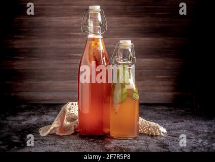 Flacons isolés de kombucha maison, un thé de fruits avec probiotique, bactéries et levure. Deuxième fermentation avec fraises et menthe avec millésime Banque D'Images