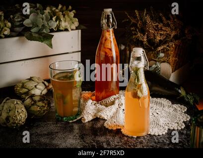 Flacons isolés de kombucha maison, un thé de fruits avec probiotique, bactéries et levure. Deuxième fermentation avec fraises et menthe avec millésime Banque D'Images