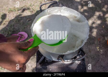 Maïs ou farine de maïs pap, un aliment de base dans de nombreux pays d'Afrique étant préparé dans un pot sur un poêle à charbon Banque D'Images