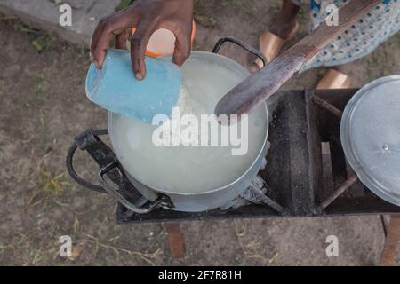 Maïs ou farine de maïs pap, un aliment de base dans de nombreux pays d'Afrique étant préparé dans un pot sur un poêle à charbon Banque D'Images