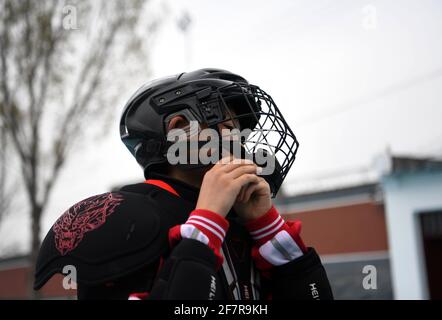 (210409) -- DENGFENG, 9 avril 2021 (Xinhua) -- UN joueur de l'équipe de hockey sur glace Shaolin Tagou met son casque à l'école d'arts martiaux Shaolin Tagou, Dengfeng City, province de Henan, en Chine centrale, le 31 mars 2021. Shaolin Tagou Martial Arts School, à quelques kilomètres du temple de Shaolin, lieu de naissance de Shaolin Kung Fu, construit son équipe de hockey sur glace. Les élèves apprennent le sport sur des patins à roulettes dans une patinoire de taille standard recouverte de plancher, au lieu de glace. La pratique des arts martiaux renforce leurs physiques et leur procure des qualités athlétiques dont le hockey sur glace a besoin, a déclaré l'entraînement Banque D'Images