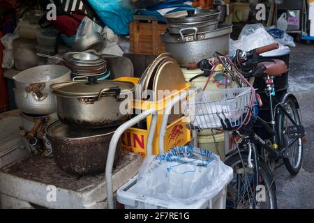 Vue de près horizontale d'un vélo stationné par une pile de casseroles et de poêles dans le marché extérieur de Tsukiji à Tokyo (Jogai-Shijo), Tsukiji, Tokyo, Japon Banque D'Images