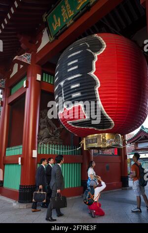 Vue verticale d'un touriste prise d'une photo de la lanterne de chochin rouge dans le temple bouddhiste Senso-Ji porte Kaminarimon, Asakusa, Tokyo Banque D'Images