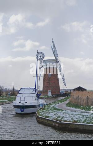 Vue sur un croiseur à moteur amarré dans la digue à côté du moulin à vent sur les Norfolk Broads à Horsey, Norfolk, Angleterre, Royaume-Uni. Banque D'Images