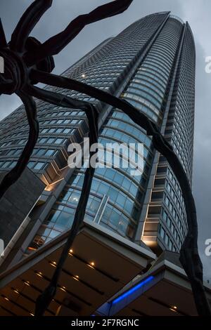 Vue verticale à angle bas de Maman en face de la tour Mori illuminée dans le complexe des collines de Roppongi, Roppongi, Minato City, Tokyo, Japon Banque D'Images