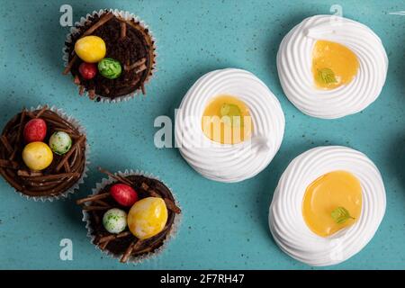 Sélection de petits gâteaux sucrés, biscuits et œufs de chocolat fourrés sur une assiette de fruits de mer faite à la main Banque D'Images