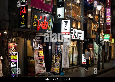 Vue de nuit horizontale d'une rangée de bars et de restaurants beaucoup de panneaux de néon torches sur Shibuya Centre-gai, Shibuya, Tokyo, Japon Banque D'Images