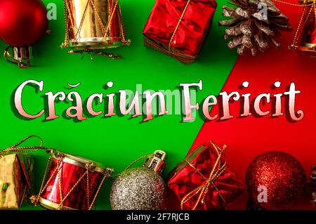 Merry Christmas en roumain thème de concept de langue avec cadre en boules couvertes de paillettes, de tambours brillants, de cône de pin et de boîtes-cadeaux sur le rouge et gre Banque D'Images