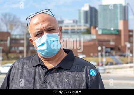 Un homme avec le coronavirus ou l'autocollant du vaccin Covid-19 dans son tee-shirt. L'autocollant est remis à ceux qui prennent l'un des vaccins approuvés à Toronto, Banque D'Images