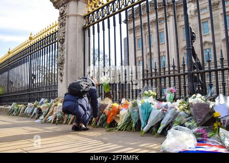 Londres, Royaume-Uni. 9 avril 2021. Une femme dépose des fleurs en hommage au prince Philip à l'extérieur de Buckingham Palace. Le duc d'Édimbourg est mort aujourd'hui, âgé de 99 ans. Credit: Vuk Valcic/Alamy Live News Banque D'Images