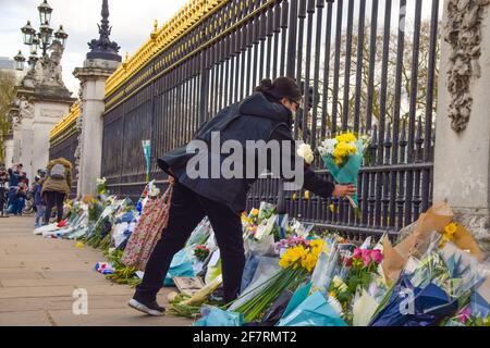 Londres, Royaume-Uni. 9 avril 2021. Une femme dépose des fleurs en hommage au prince Philip à l'extérieur de Buckingham Palace. Le duc d'Édimbourg est mort aujourd'hui, âgé de 99 ans. Credit: Vuk Valcic/Alamy Live News Banque D'Images