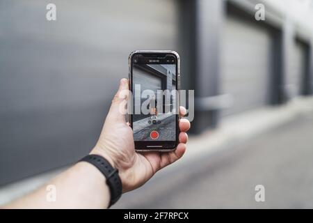 Main mâle tenant un téléphone et faisant la vidéo d'un ami Banque D'Images