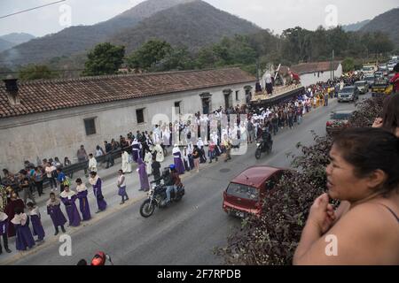 Des hommes bien habillés en costume et des femmes en tenue traditionnelle participent à la procession solennelle Semana Santa à Antigua, au Guatemala. Banque D'Images