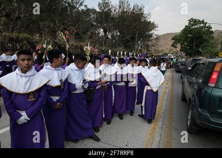 Les Cucuruchos en robes violettes se déroulent solennellement dans les rues d'Antigua, au Guatemala, pendant les célébrations traditionnelles de la semaine Sainte de Semana Santa. Banque D'Images