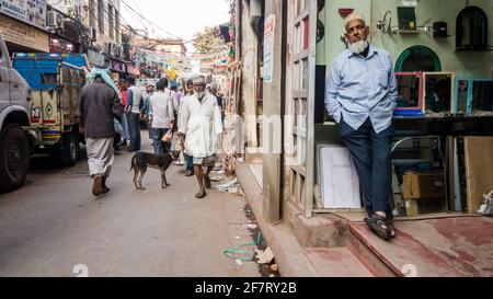 Kolkata, Bengale-Occidental, Inde - janvier 2018: Un commerçant musulman âgé debout dans son magasin sur une rue de marché très fréquentée dans le quartier de Barabazar de la ville de Banque D'Images