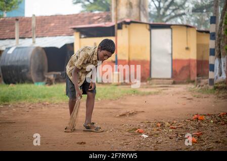 Varanasi, Inde. 10-14-2019. Un garçon balayant les locaux de l'école où les enfants font du sport comme football ou panier . Banque D'Images