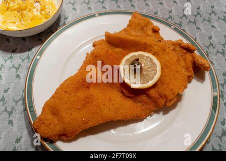 Wiener Schnitzel, escalope de veau pané viennois avec salade de pommes de terre, garni d'une roue au citron, d'un anneau d'anchois et d'une couche Banque D'Images