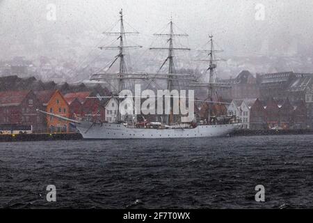 Bateau à voile à grande hauteur Christian Radich (construit en 1937) dans une tempête de neige. Au quai de Bryggen, dans le vieux port de Bergen, en Norvège. Banque D'Images