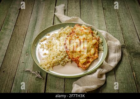 poulet grillé aux ananas et fromage au riz dans une élégante assiette en porcelaine verte, sur l'ancienne table en bois vert Banque D'Images