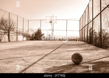 Photo rustique d'un ancien basket-ball sur un terrain vide Banque D'Images