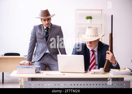 Deux employés de cow-boy dans un concept drôle Banque D'Images