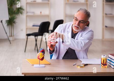 Ancien professeur de dentiste assis dans la salle de classe Banque D'Images