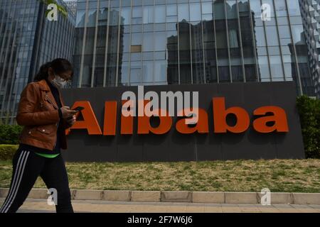 Un piéton passe devant le siège d'Alibaba à Pékin.l'Administration d'État pour la réglementation du marché de la Chine a ensablé Alibaba avec une amende de près de 2.8 milliards de dollars pour des pratiques monopolistiques « alternativement ». Alibaba a publié une lettre ouverte : la punition est un signal d'alarme et un coup de fouet, va créer un environnement de plate-forme plus ouvert. Banque D'Images