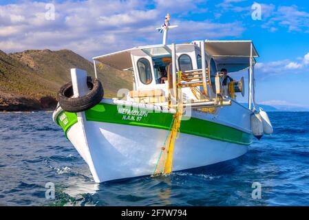 Les pêcheurs pêchent des poissons frais à l'aide de filets de pêche jaunes, sur un bateau de pêche, en Crète, en Grèce Banque D'Images