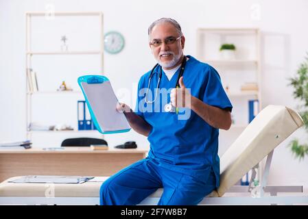 Médecin senior prenant des notes dans la clinique Banque D'Images