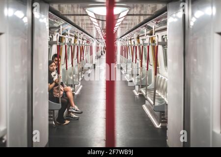 Hongkong, Chine - novembre, 2019: Couple à l'intérieur du métro presque vide / MTR train à Hong Kong Banque D'Images