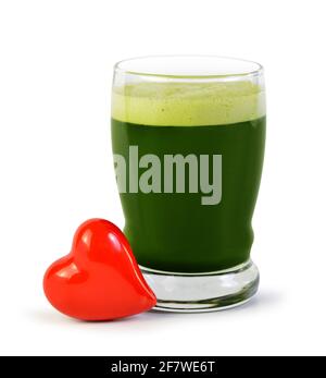 Boisson au jus d'orge verte dans le verre et coeur rouge isolé sur fond blanc. Détox super-alimentation. Le concept de saine alimentation. Banque D'Images