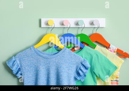 Cintres avec vêtements pour enfants sur fond de couleur Banque D'Images