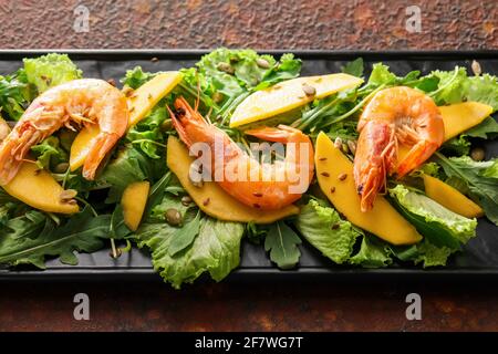 Assiette de salade de mangue fraîche avec crevettes sur fond de grunge Banque D'Images