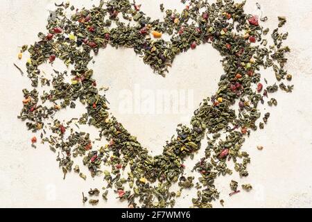 Forme de coeur en thé vert sec sur fond clair Banque D'Images