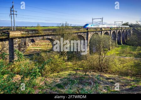 Un train traversant le viaduc de Sankey à Earlestown au-dessus de la vallée de Sankey. C'est le premier viaduc de chemin de fer majeur dans le monde. Banque D'Images